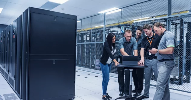 Cinco compañeros de trabajo revisan los riesgos para los servidores en una computadora e implementan una estrategia de mitigación de riesgos.