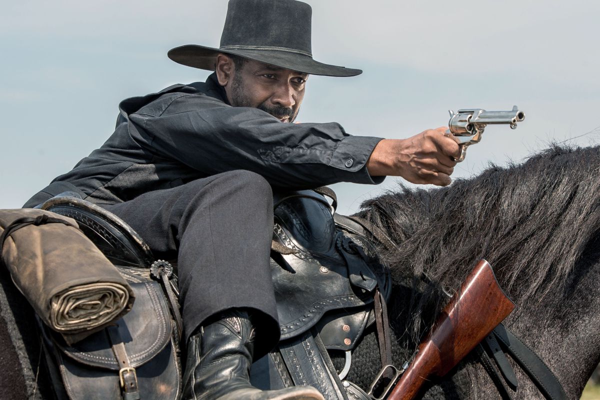 دينزل واشنطن يوجه مسدسه أثناء ركوبه حصانًا في فيلم The Magnificent Seven