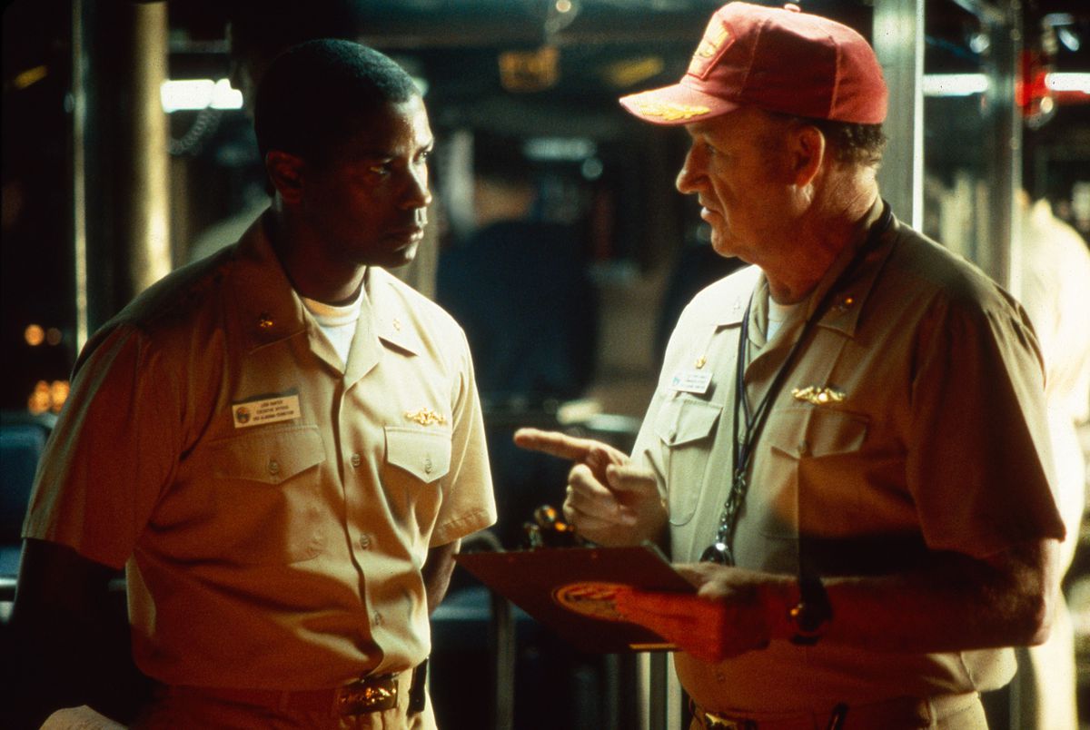 Denzel Washington en Gene Hackman kijken elkaar intens aan terwijl ze op een onderzeeër zitten, in Crimson Tide.
