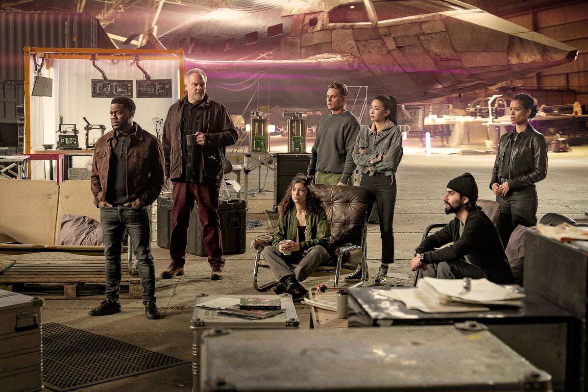 El elenco de Lift, incluidos Kevin Hart y Gugu Mbatha-Raw, están en un hangar con un avión CGI falso detrás de ellos.