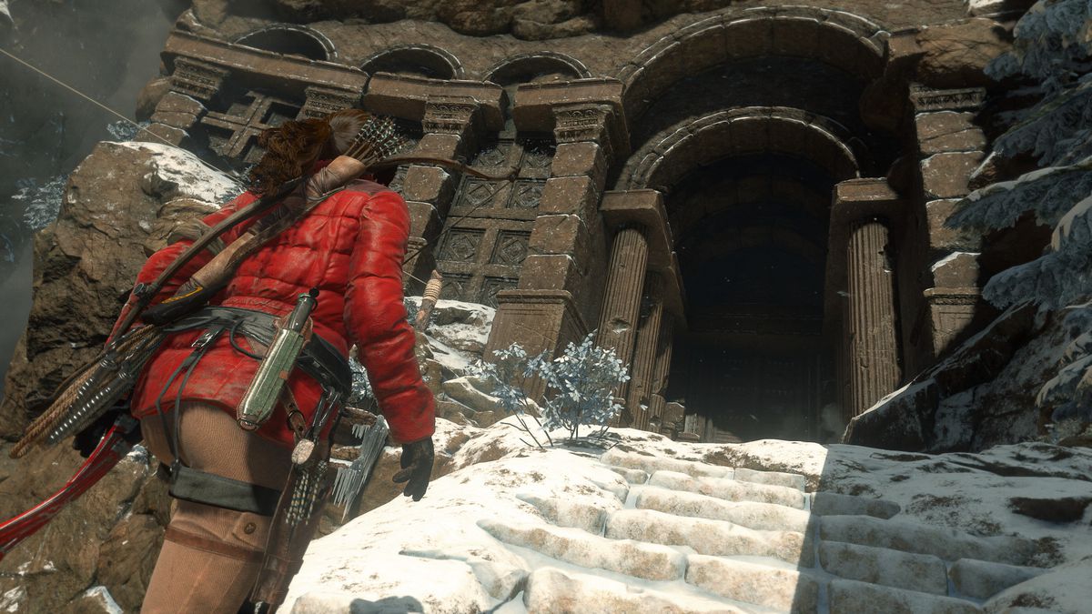 Lara Croft con una chaqueta de invierno roja subiendo las escaleras nevadas de un templo en Rise of the Tomb Raider.