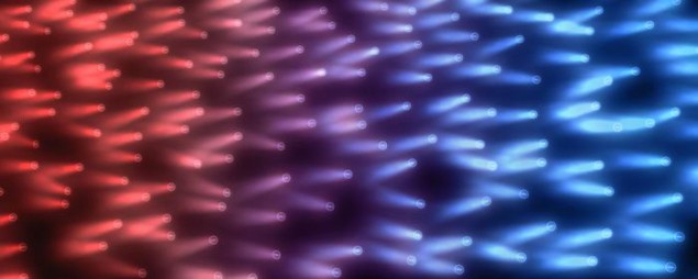 Ilustración de electrones que interactúan fuertemente y transportan calor y carga desde regiones más cálidas a más frías de un material cuántico, representados por destellos rojos en el lado izquierdo de la ilustración y sombreados en destellos violetas y azules a la derecha.