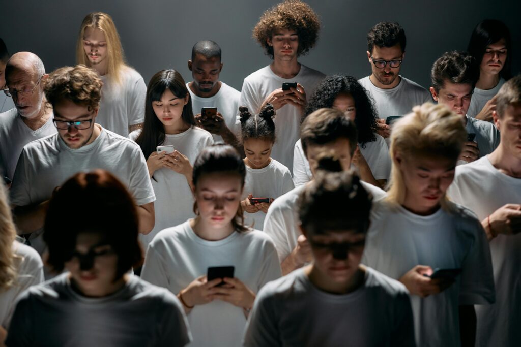 Grupp människor som står bredvid varandra och alla tittar på sina telefoner