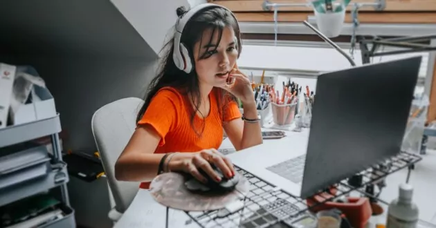 người trẻ đeo tai nghe hát khi làm việc trên máy tính xách tay ở nhà