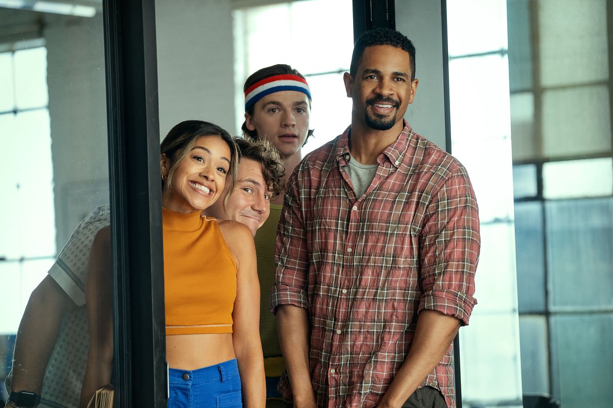A group of young people standing next to a glass door and smiling.