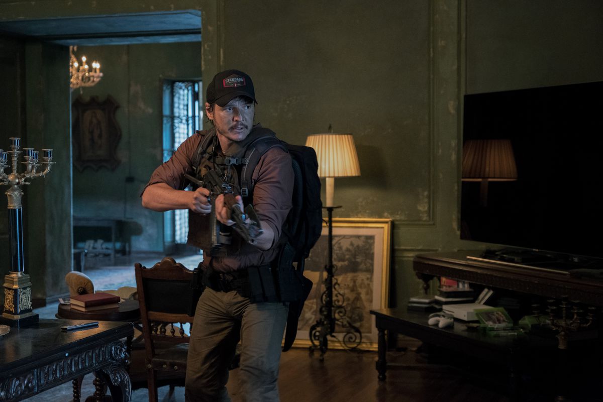 Pedro Pascal sostiene un arma y lleva una mochila en una casa ornamentada en Triple Frontera.