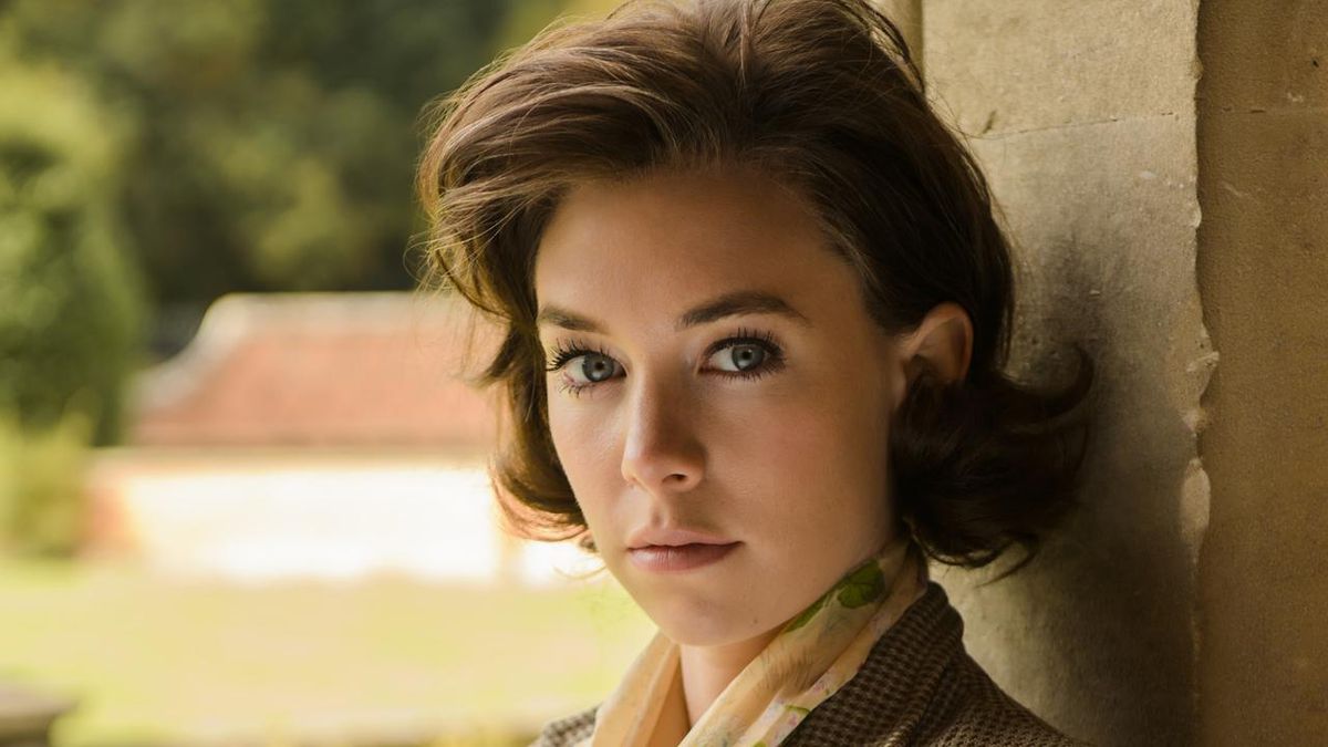 Vanessa Kirby in costume in 50s era costume in Queen &amp; Country staring at camera