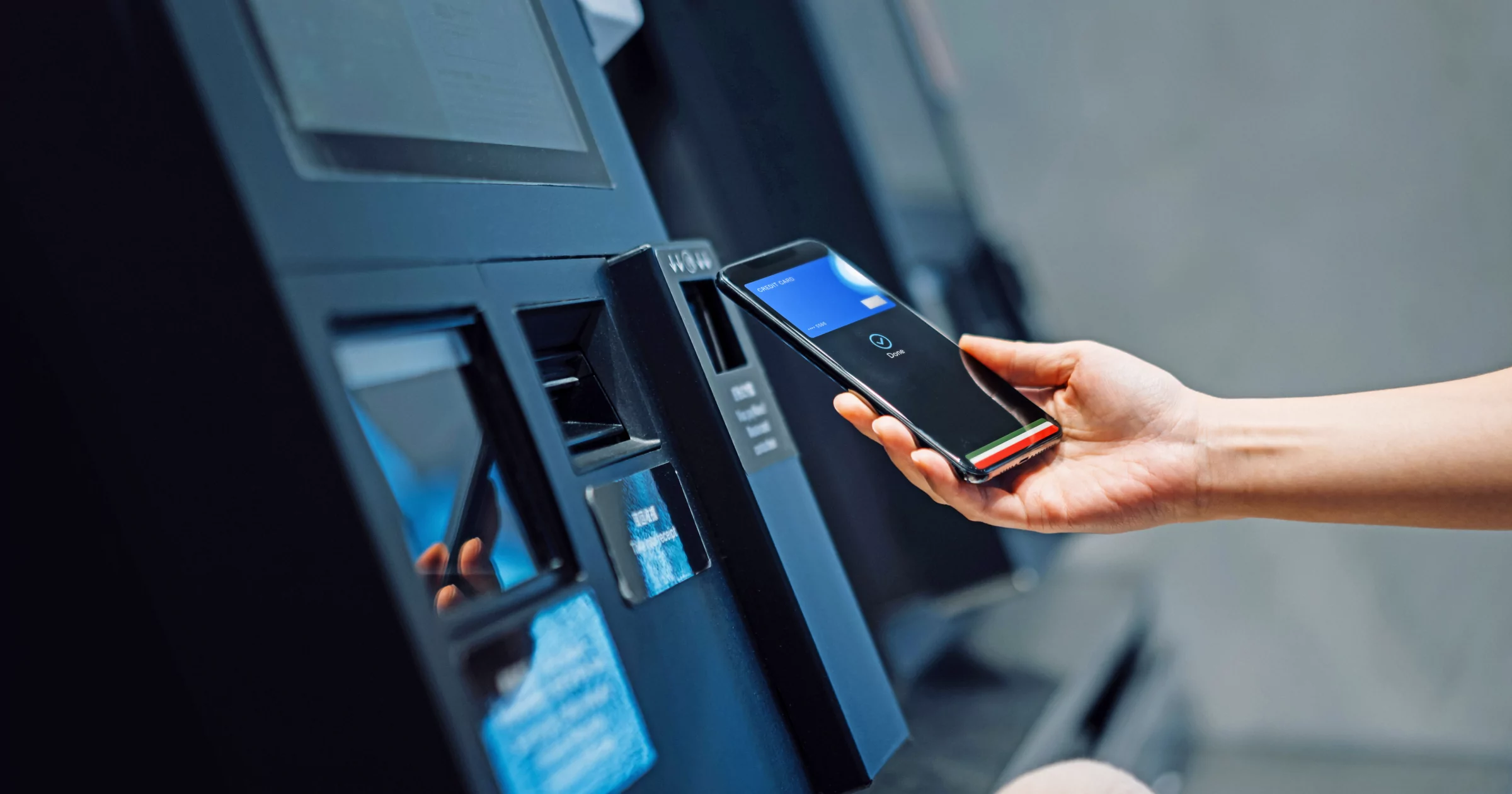 在 ATM 機上使用電話的人的手
