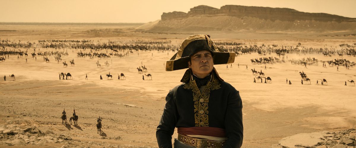 Napoléon se tient fier devant un champ de bataille désertique dans le film Napoléon