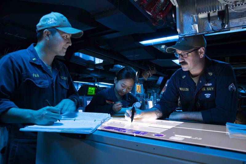 미 해군 수석 소나 기술자(수상) Andrew Mullen(오른쪽)이 Arleigh Burke급 유도 미사일 구축함 USS Decatur의 전투 정보 센터에서 교육을 제공하고 있습니다.