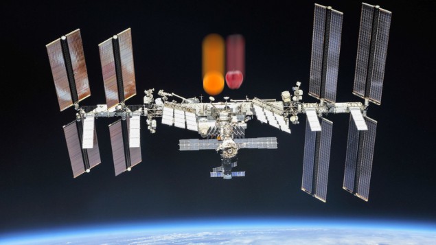 地球の周りを周回する国際宇宙ステーションの写真。その上に落ちてくるリンゴとオレンジが重なっている
