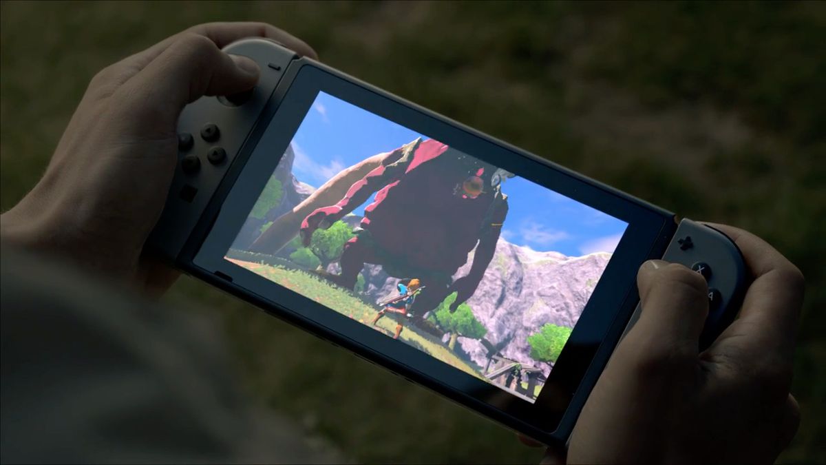 händer som håller en Nintendo Switch som spelar Zelda: Breath of the Wild