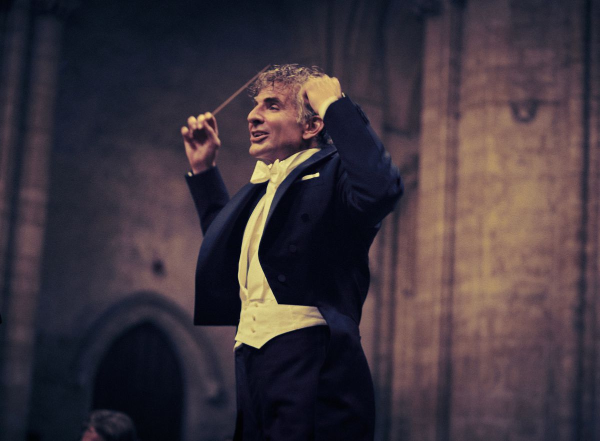 Bradley Cooper als Leonard Bernstein dirigeert in een smoking in Maestro
