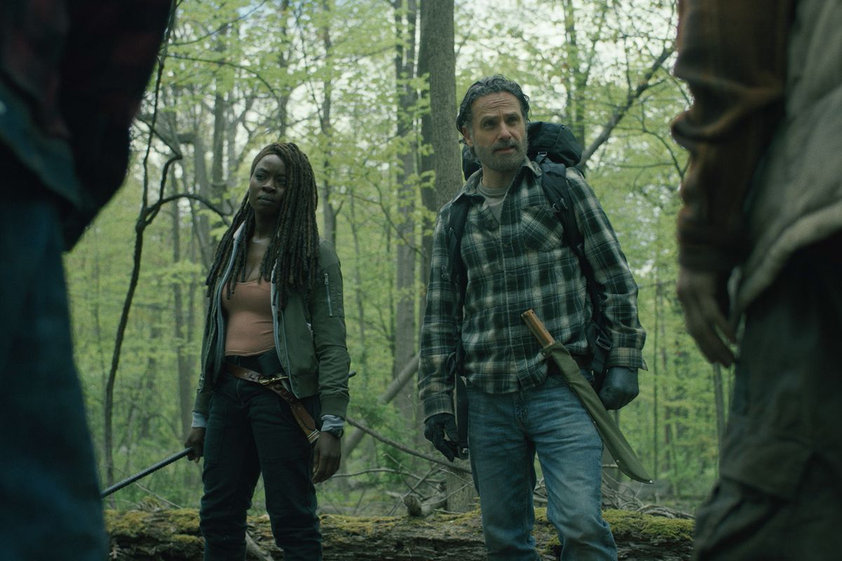 Michonne (Danai Gurira) y Rick (Andrew Lincoln) de pie y mirando a algunos zombis en el bosque en una imagen fija de Los que viven.