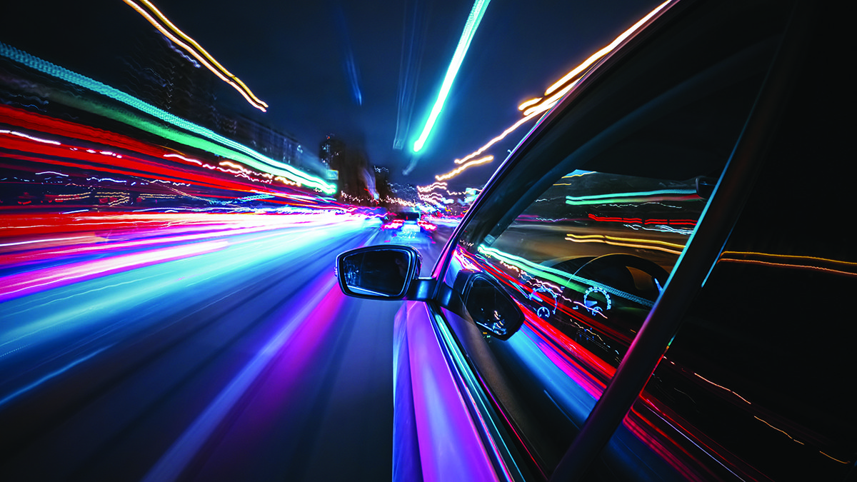 Una vista desde la ventana de un auto por la noche mostrando luces en un lapso de tiempo