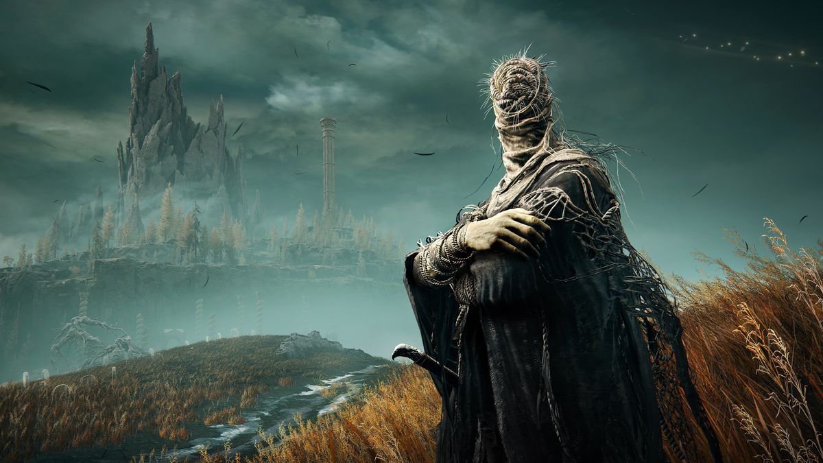 One of Miquella’s followers stands with arms folded in a grassy field, with a tower far in the distance in a screenshot from Elden Ring: Shadow of the Erdtree