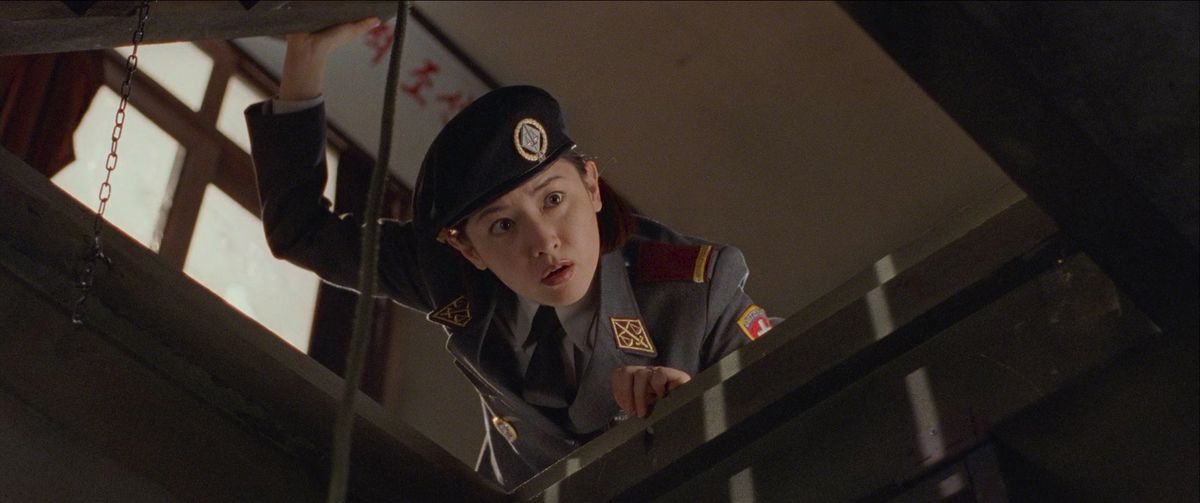 Lee Young-ae peers down what looks like a trap door or a staircase in a house in Joint Security Area.
