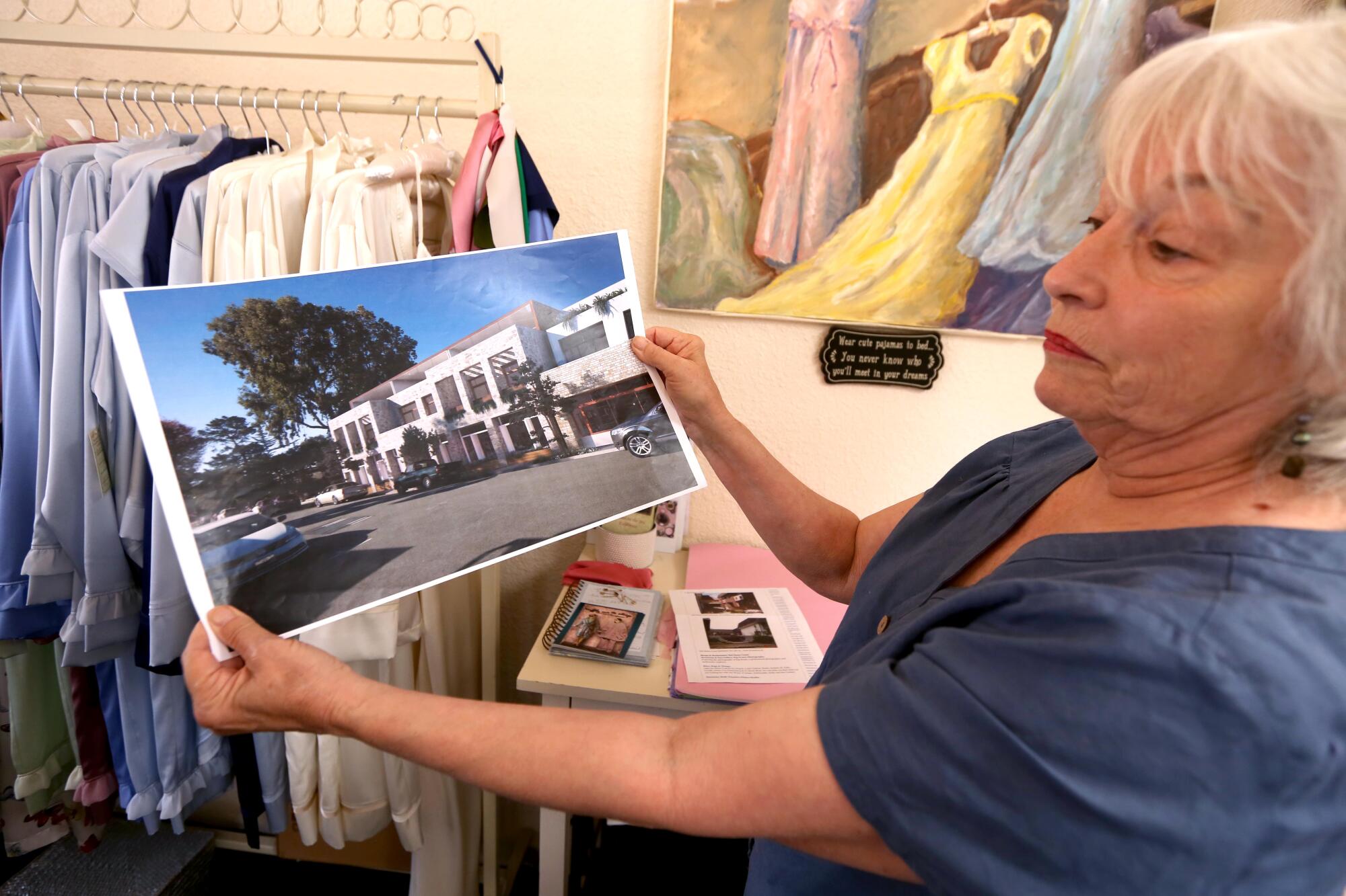 A woman holds up a proposed architectural design.